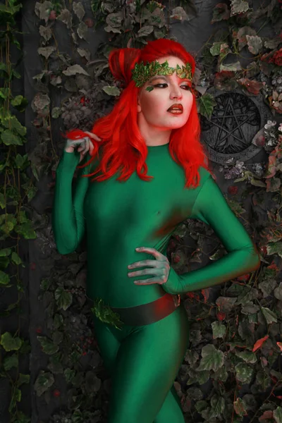 Όμορφη Νεαρή Γυναίκα Κόκκινα Μαλλιά Θέτοντας Πράσινο Κοστούμι Κοντά Φύλλα — Φωτογραφία Αρχείου