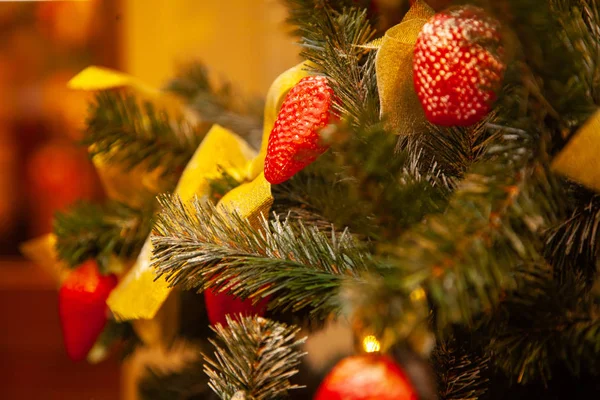 the xmas tree is decorated with strawberries, bows and ribbons