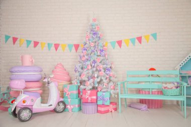 Güzel beyaz Noel ağacı dekore edilmiş pembe çiçekler ve mor kurdeleler ve fiyonklar şirin çocukça Oda tarafından. Kimse.