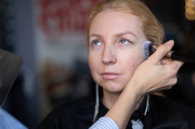 profesyonel makyöz makyaj adım adım bir kadın sarışın yüzünde geçerlidir