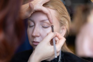 profesyonel makyöz makyaj adım adım bir kadın sarışın yüzünde geçerlidir