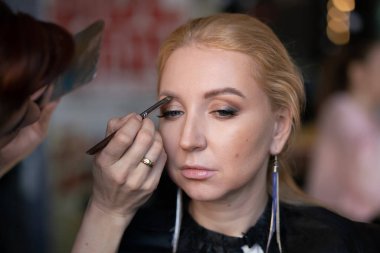 profesyonel makyöz makyaj adım adım bir kadın sarışın yüzünde geçerlidir
