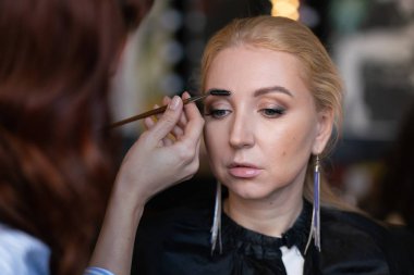 profesyonel makyöz makyaj adım adım bir kadın sarışın yüzünde geçerlidir