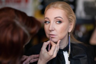 profesyonel makyöz makyaj adım adım bir kadın sarışın yüzünde geçerlidir