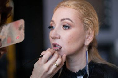 profesyonel makyöz makyaj adım adım bir kadın sarışın yüzünde geçerlidir