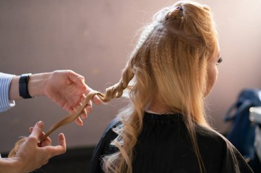 yaparken bir Kuaför ana salonda bir oluklu ve bir perma saçları güzel yetişkin sarışın istemci bir sandalyede oturur