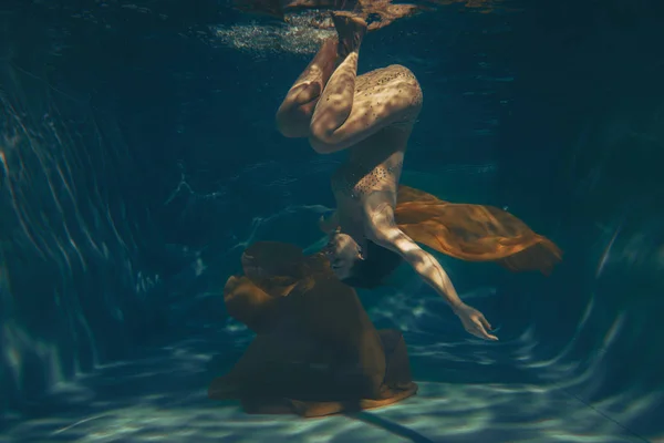 cute sporty girl swims underwater as a free diver alone