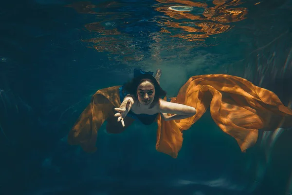 cute sporty girl swims underwater as a free diver alone
