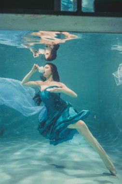 eğleniyor ve meditatively su altında bir elbise içinde yüzme sırasında kahvaltı için yatıştırıcı çay içme kız