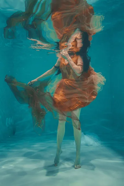 Όμορφο Μοντέλο Κορίτσι Υποβρύχια Κολυμπά Πορτοκαλί Φόρεμα Και Απολαμβάνει Την — Φωτογραφία Αρχείου