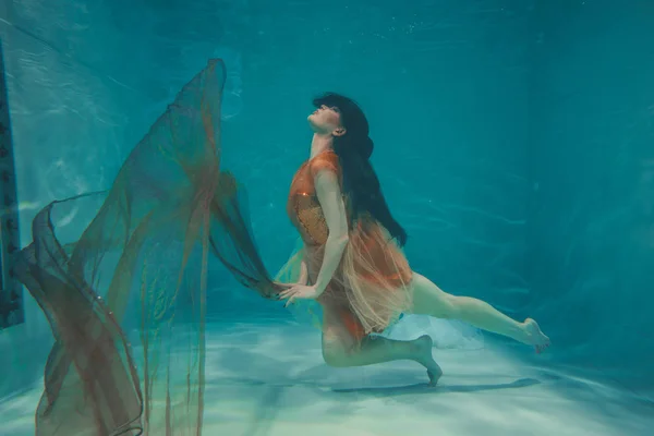 Gyönyörű Modell Lány Úszik Víz Alatt Narancssárga Ruha Élvezi Relaxációs — Stock Fotó