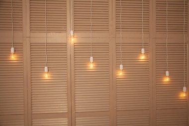 odanın içinde bej bir ahşap dolap arka plan üzerinde uzun teller ampulleri dayan