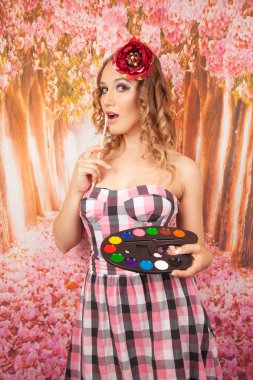 güzel bir kız standları bir fırça ve boya ve rüyalar, gülümsüyor, eğlenir