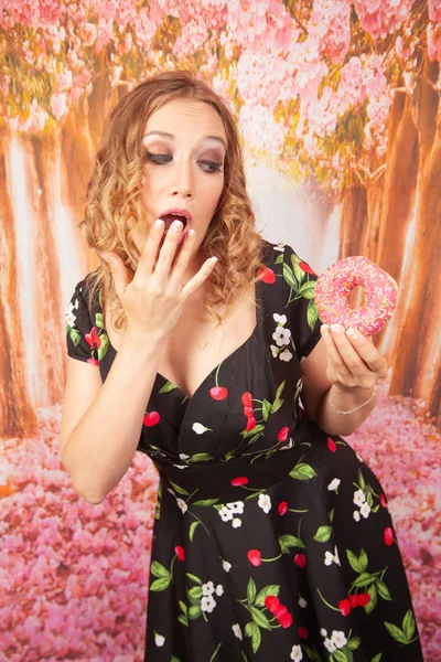 Bela Menina Preto Pin Vestido Divertindo Jogando Com Rosquinhas Rosa — Fotografia de Stock