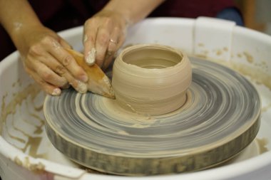Potter's tekerlek üzerinden ham ıslak kil üzerinde kirli silah ile bir sürahi kadın yapar