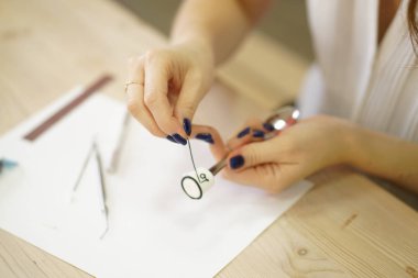 kadın masada oturur ve bir çay kaşığı kakao hatmi ve yazıt sevgi, adım adım masterclass polimer kil ile şeklinde üzerinde bir dekorasyon yapar