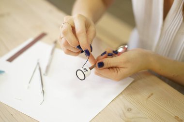 kadın masada oturur ve bir çay kaşığı kakao hatmi ve yazıt sevgi, adım adım masterclass polimer kil ile şeklinde üzerinde bir dekorasyon yapar