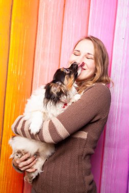 kahverengi bir süveter kollarını bir köpek ile poz güzel beyaz kız