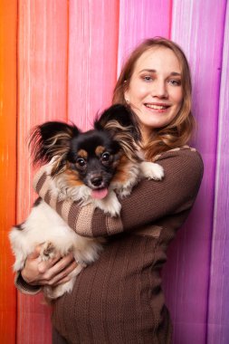 kahverengi bir süveter kollarını bir köpek ile poz güzel beyaz kız