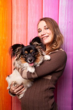 kahverengi bir süveter kollarını bir köpek ile poz güzel beyaz kız