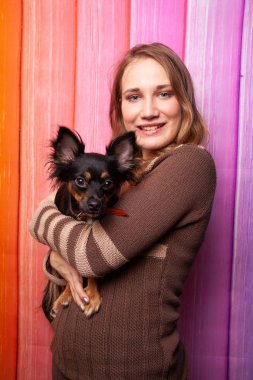 kahverengi bir süveter kollarını bir köpek ile poz güzel beyaz kız