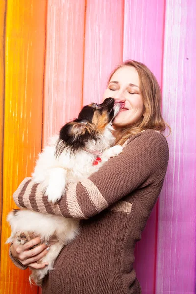 kahverengi bir süveter kollarını bir köpek ile poz güzel beyaz kız