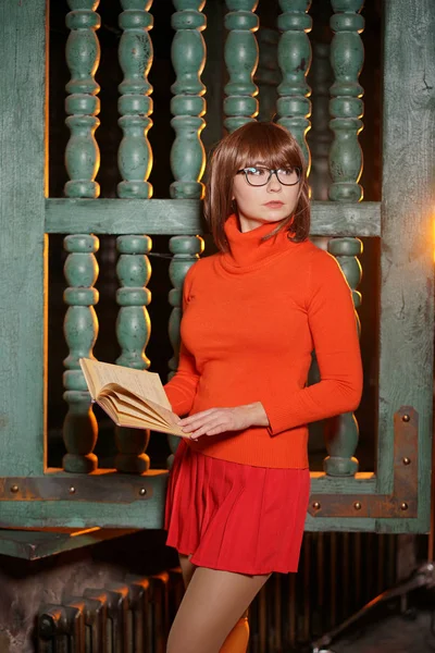 cute girl with glasses in orange clothes is a good student and a nerd