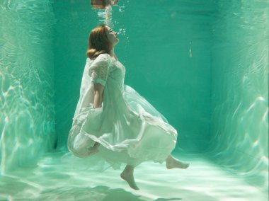 İnce beyaz kadın poz altında sıcak su derinlikleri giysileri yalnız