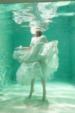 İnce beyaz kadın poz altında sıcak su derinlikleri giysileri yalnız