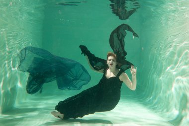 İnce beyaz kadın poz altında sıcak su derinlikleri giysileri yalnız