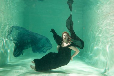 İnce beyaz kadın poz altında sıcak su derinlikleri giysileri yalnız