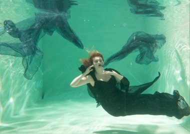 İnce beyaz kadın poz altında sıcak su derinlikleri giysileri yalnız