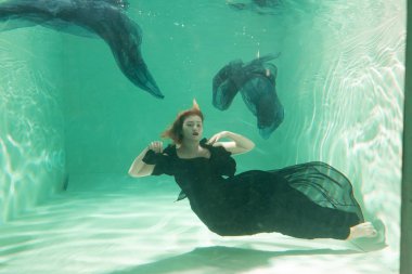 İnce beyaz kadın poz altında sıcak su derinlikleri giysileri yalnız