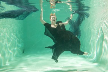 İnce beyaz kadın poz altında sıcak su derinlikleri giysileri yalnız