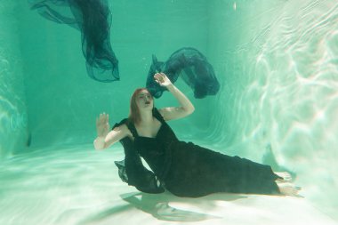 İnce beyaz kadın poz altında sıcak su derinlikleri giysileri yalnız