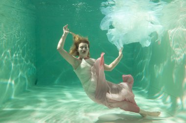 İnce beyaz kadın poz altında sıcak su derinlikleri giysileri yalnız