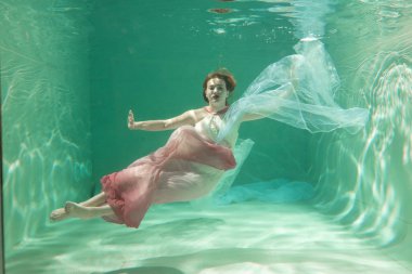 İnce beyaz kadın poz altında sıcak su derinlikleri giysileri yalnız