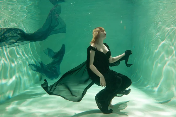 İnce beyaz kadın poz altında sıcak su derinlikleri giysileri yalnız