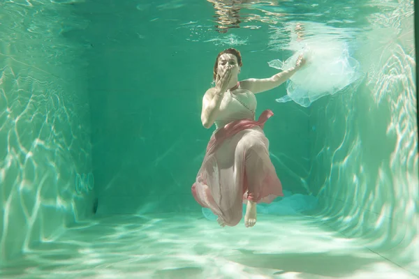 İnce beyaz kadın poz altında sıcak su derinlikleri giysileri yalnız