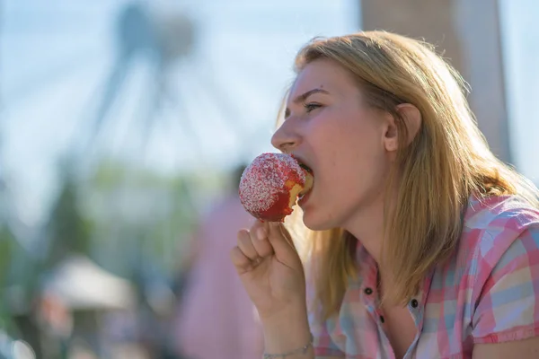 Młoda Kobieta Jedzenia Gryzienie Czerwone Jabłko Karmelu Parku Słoneczny Dzień — Zdjęcie stockowe