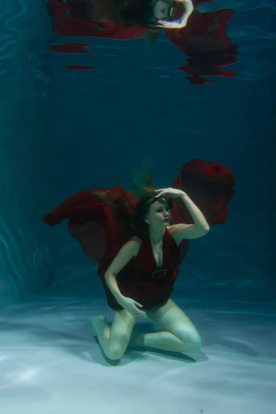 美丽的自由潜水员妇女游泳在长长的红色晚礼服下独自在深 — 图库照片
