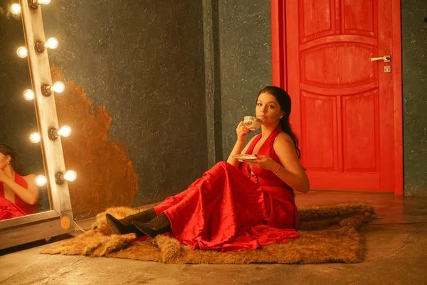 Hermosa Chica Vestido Rojo Sienta Una Alfombra Piel Bebe Café — Foto de Stock