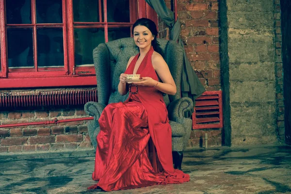 Εύθυμος Μελαχρινή Καυκάσιος Γυναίκα Κάθεται Στο Κόκκινο Μακρύ Βραδινό Φόρεμα — Φωτογραφία Αρχείου