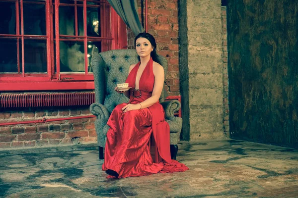 Εύθυμος Μελαχρινή Καυκάσιος Γυναίκα Κάθεται Στο Κόκκινο Μακρύ Βραδινό Φόρεμα — Φωτογραφία Αρχείου