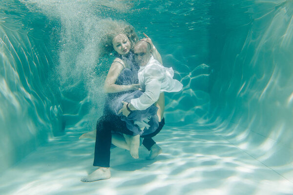 beautiful romantic couple of lovers hugging gently under water