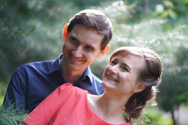 yeşil yaz Park'ta yürüyordunuz oldukça beyaz aşk çift gülümsüyor öpüp sahip