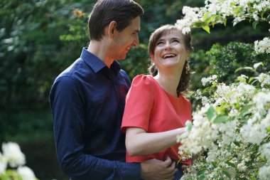 yeşil yaz Park'ta yürüyordunuz oldukça beyaz aşk çift gülümsüyor öpüp sahip