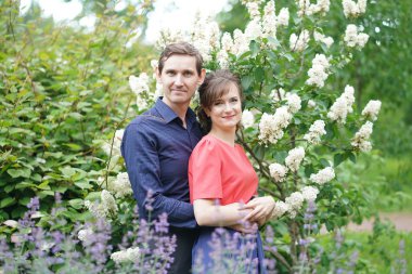 yeşil yaz Park'ta yürüyordunuz oldukça beyaz aşk çift gülümsüyor öpüp sahip