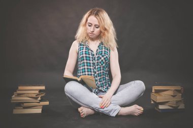 öğrenmek için kitaplar ve çok katta oturan genç ve güzel öğrenci kız yorgun