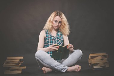 öğrenmek için kitaplar ve çok katta oturan genç ve güzel öğrenci kız yorgun